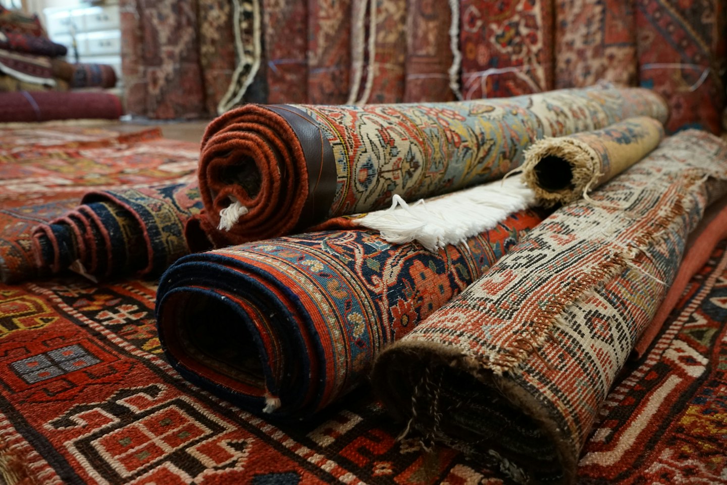 Intricate patterned rugs stacked together on a larger rug.