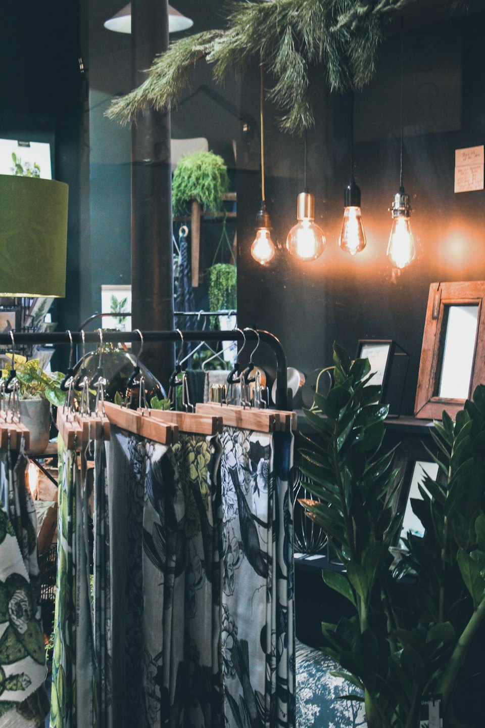 Patterned fabric samples hang from a wooden rail in a boutique.