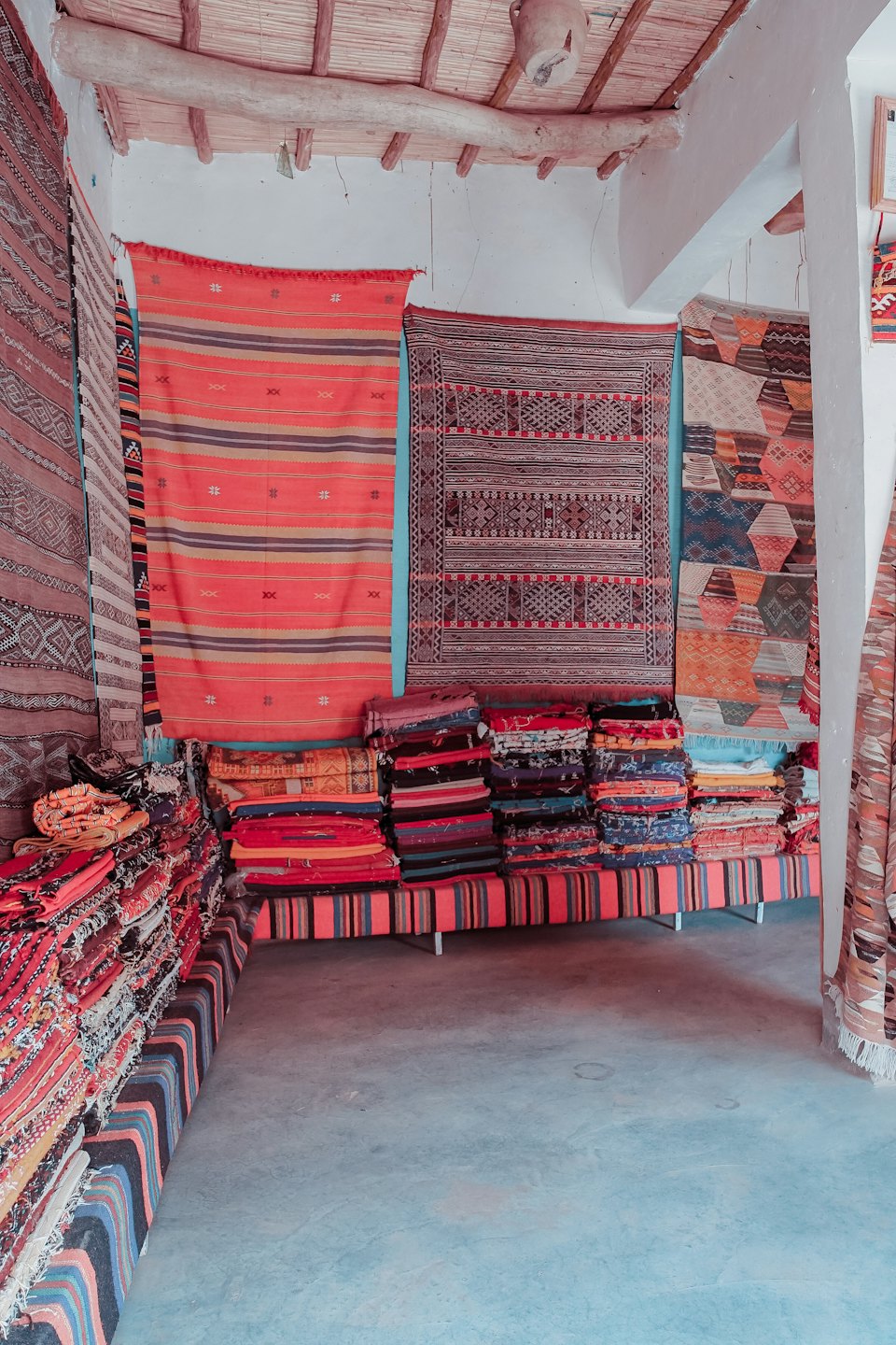 Colorful patterned rugs displayed in an indoor shop.